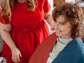 A colour analyst looking at a happy client in  neutral drapes for an autumn season
