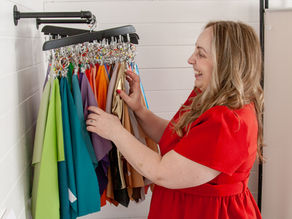 Owner, colour analyst looking through hanging fabric colour drapes.