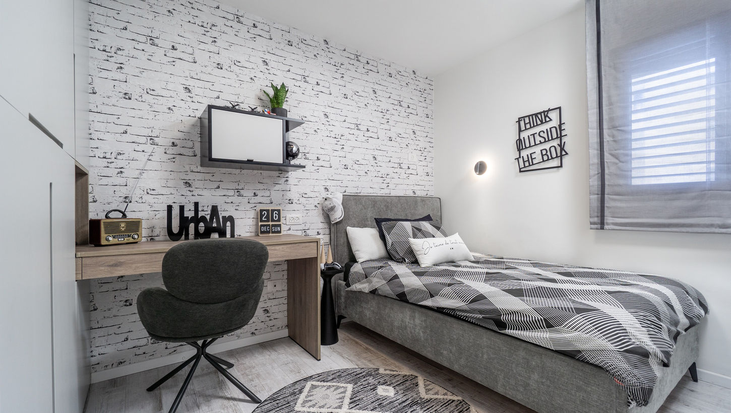 מבט אל המיטה, שולחן הכתיבה והטפט בריקים