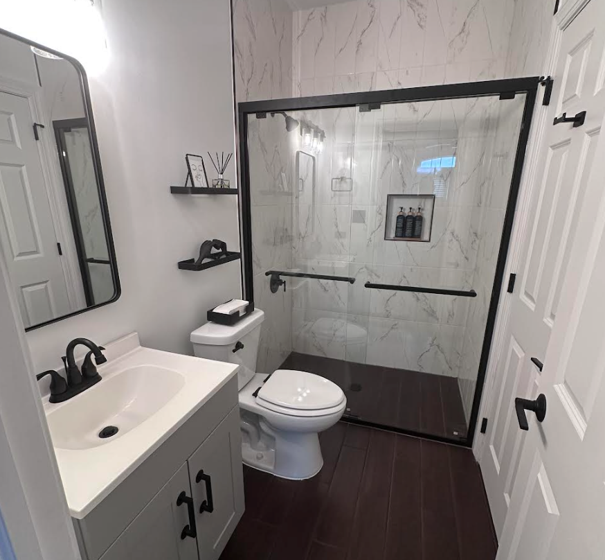 Modern staged bathroom with white vanity and dark shower