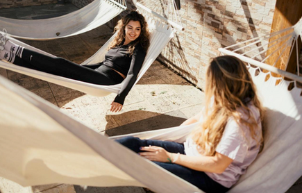 2 girls sat in hammocks