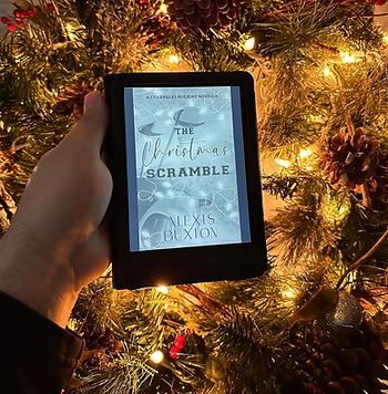 a hand holding a kindle near a small waterfall with the book Bittersweet by Carrie Aarons on the screen