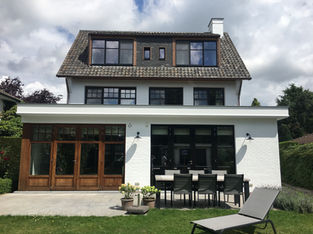 Geschilderde achtergevel met terras.