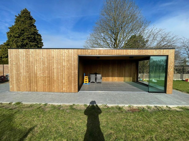 Thermowood tuinhuis met zithoek naast met glazen wanden