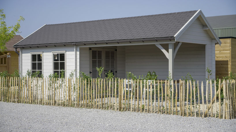 Landelijk tuinhuis in het wit met zadeldak en grote overdekte ruimte naast