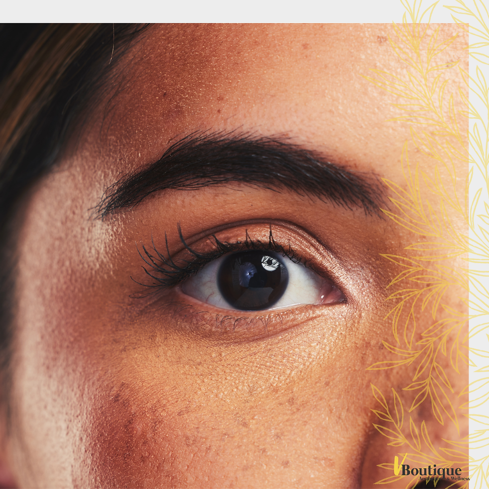 Close-up of a brown eye and eyebrow on a face, with a gold leaf border and a small Boutique Wellness logo in the corner.