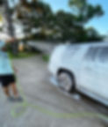 man spraying foam cannon on car during detailing