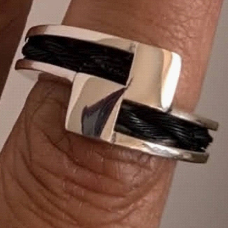 Silver Crossover Ring With Dark Horse Hair Displayed On Finger Showing Front View