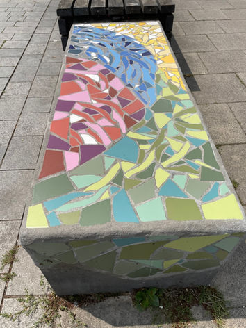 Mosaik auf einer Betonbank in verschiedenen Grün-  und Lila-Tönen