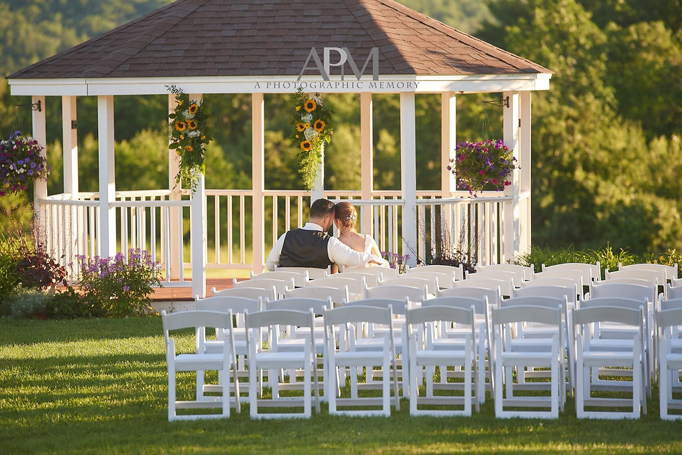 A newlywed couple sitting in front of Dell-Lea's gazebo.