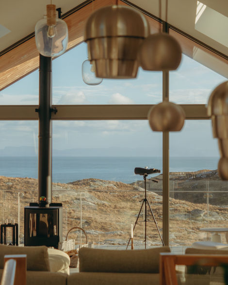 a living room with a view of the ocean and mountains