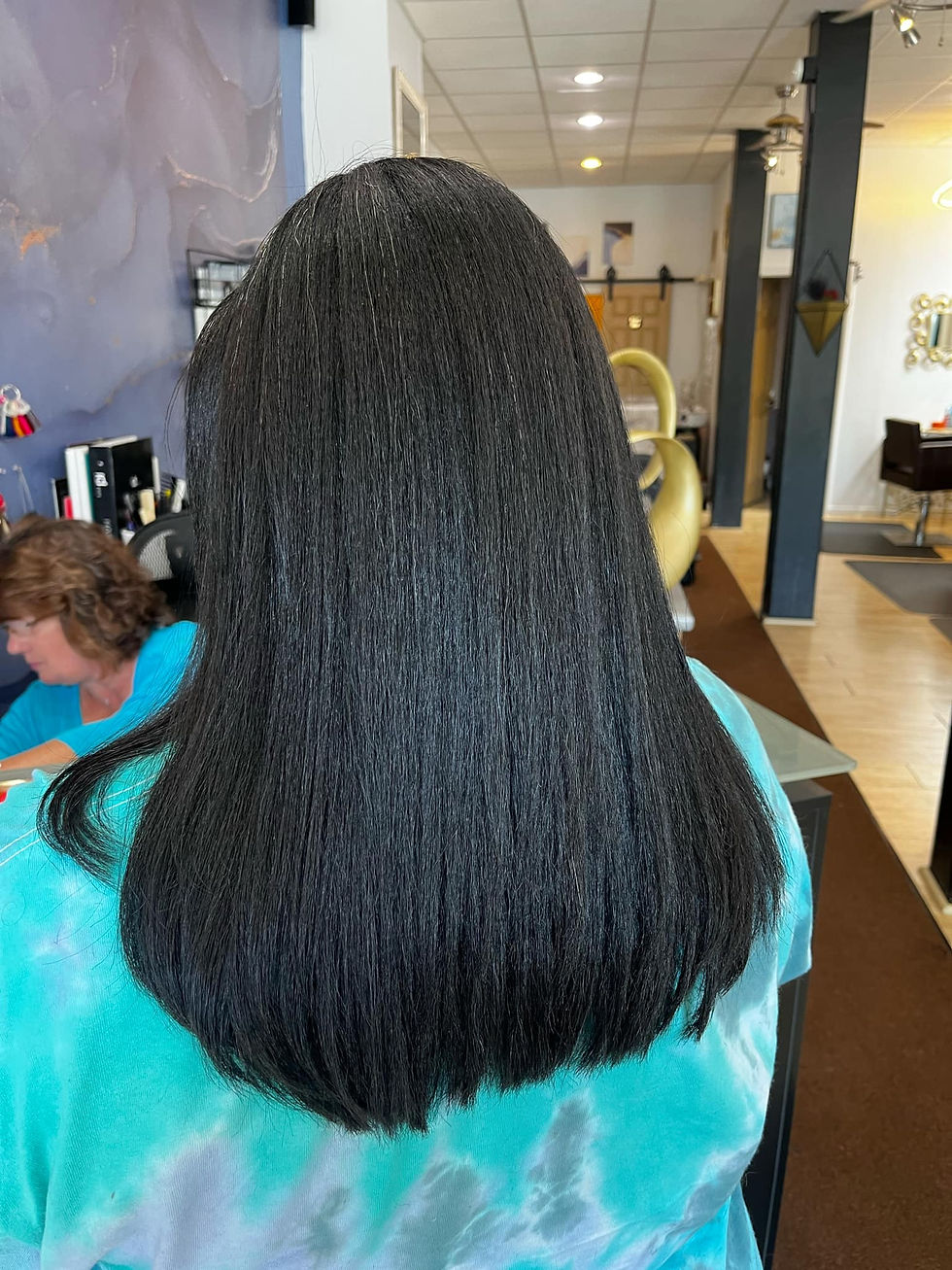 Close-up of a Black woman's smooth, straightened hair from behind