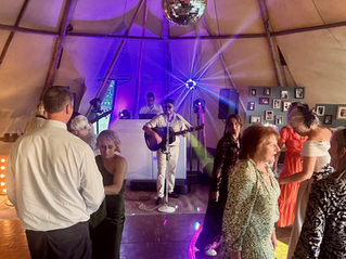 Wedding singer (Tom Powell) performing outdoors in a wedding marquee with a full dancefloor.