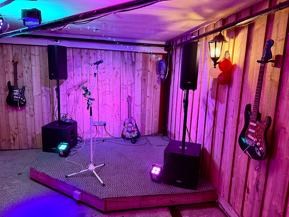 Rustic stage setting with fairy lights and stage lights at Fletcher’s Farm