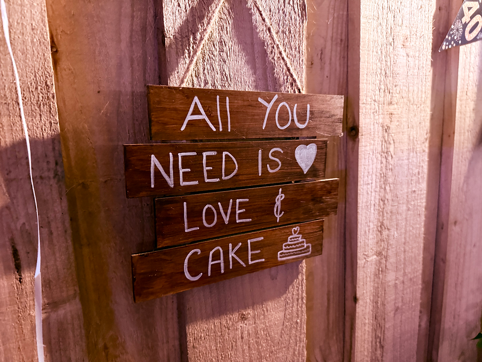 Rustic basement events space with warm lighting and wooden beams and a wooden love sign