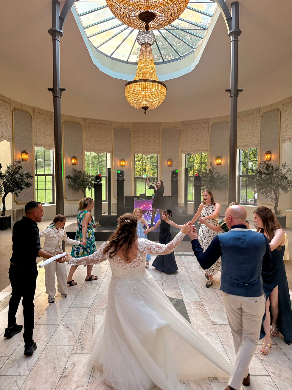 Lively wedding dancefloor with bride, groom and guests dancing and live singer performing