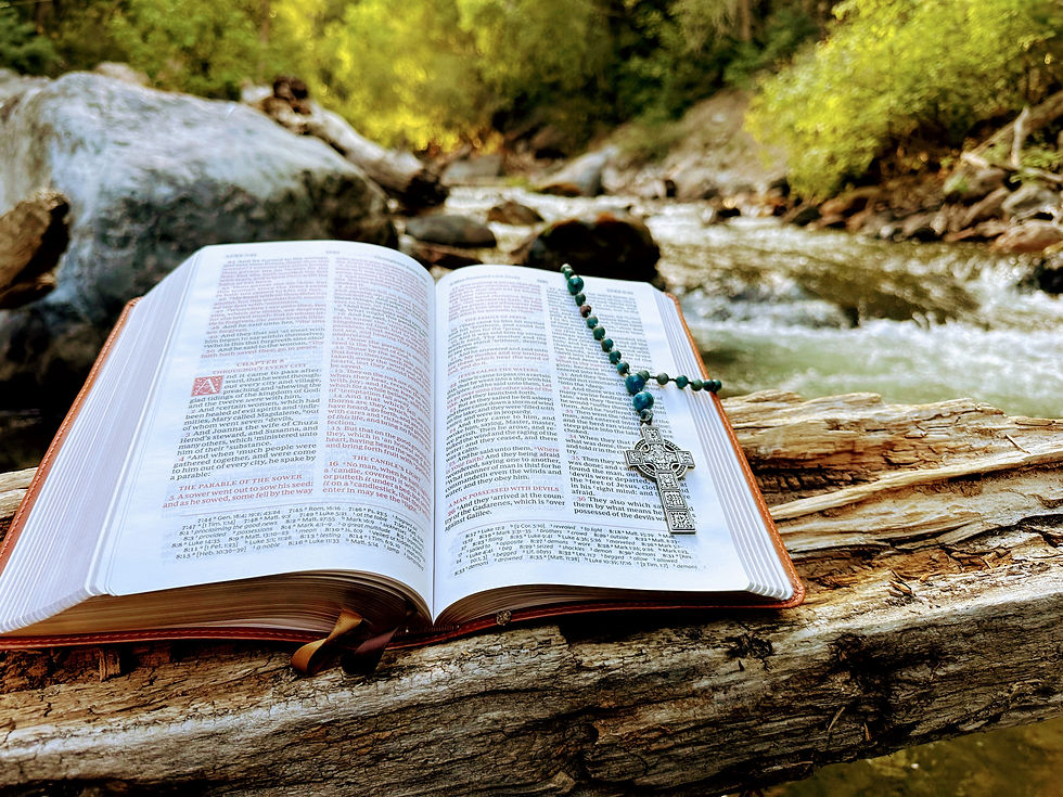 Anglican Rosary in an open Holy Bible next to a stream.