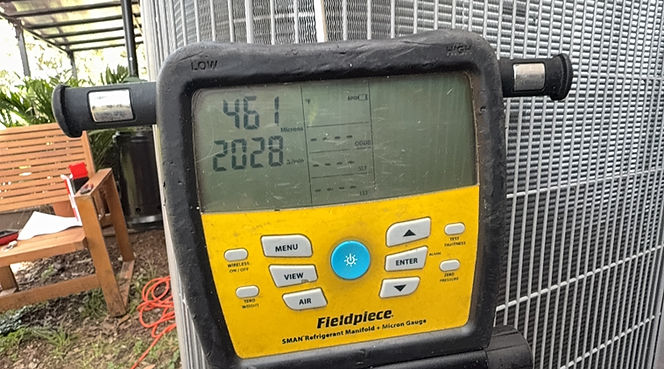 Digital refrigerant manifold gauge connected to an outdoor air conditioning unit