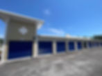 New self storage units with blue doors under a clear sky