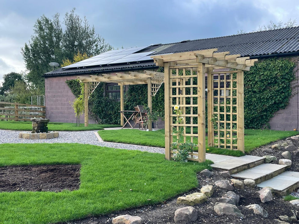 Garden view showing lawn, trees, pergolas, and gravel paths under dramatic sky.