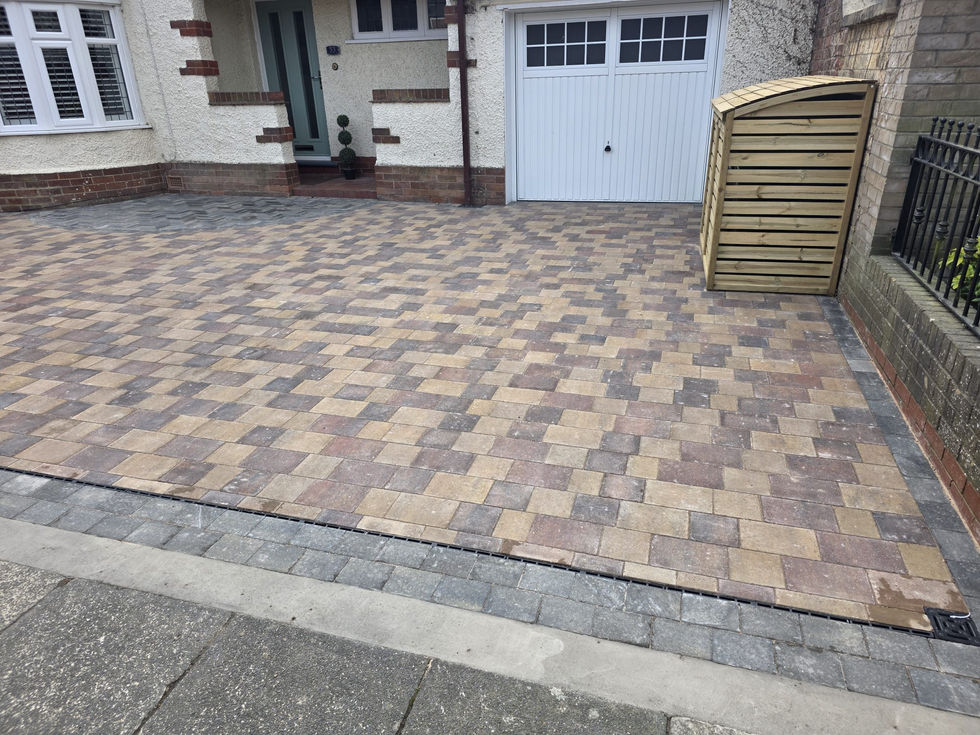 Completed driveway installation outside a detached home with contrasting border paving and clean lines.