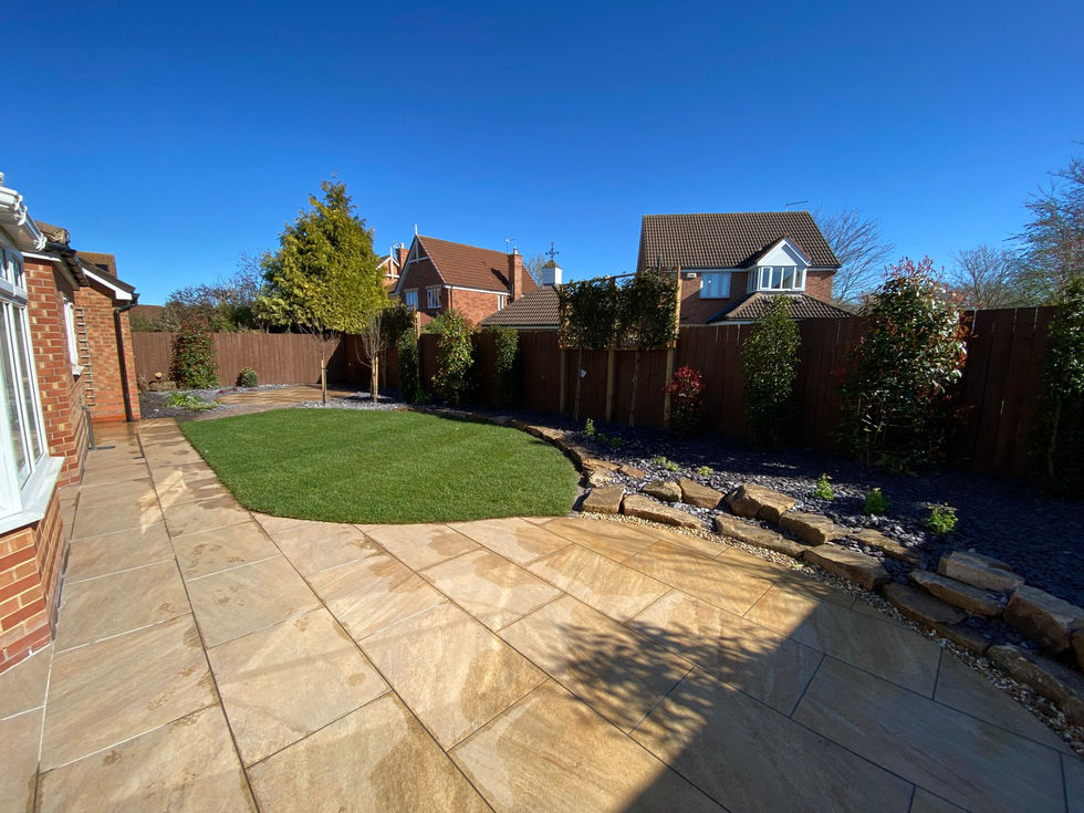Large porcelain patio area with curved edges and raised planting borders
