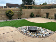 Landscaped garden with artificial grass, patio design and wooden fence. Garden Design.