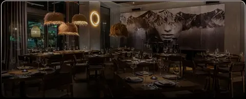 Interior de restaurante Rosa Negra Miami con iluminación tenue y mural artístico.