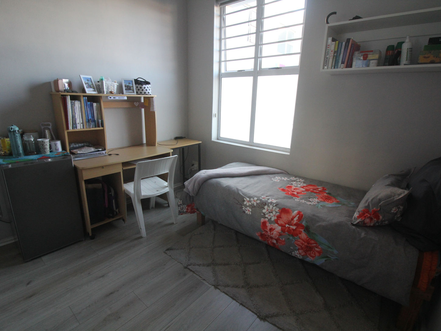 Bedroom that includes a desk, bed, study area, and mini fridge.