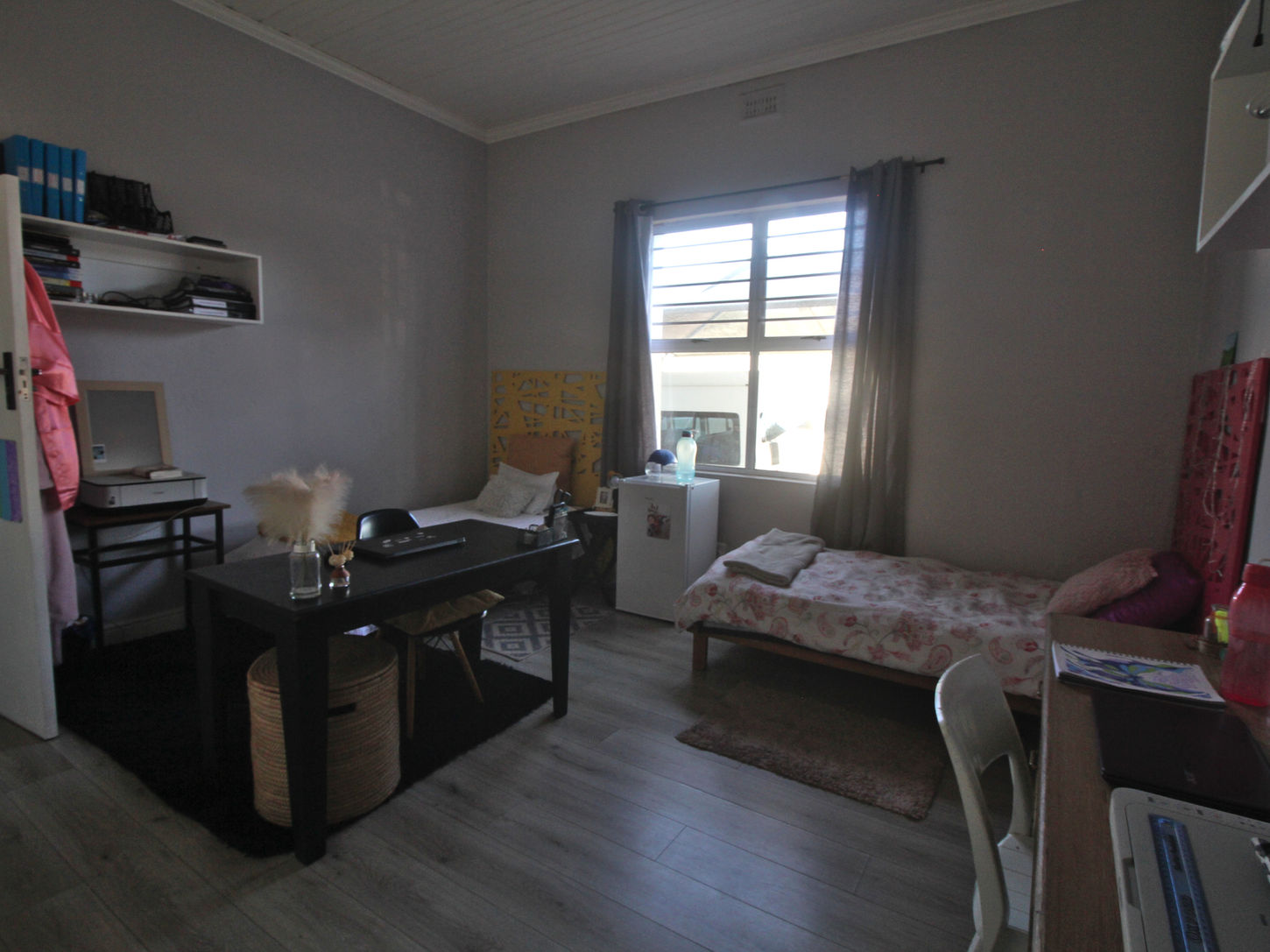 Bedroom that includes a desk, bed, study area, and mini fridge.