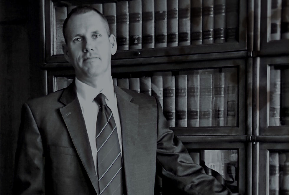 Attorney Ryan Schuenke standing in front of law books at Schuenke Law Firm