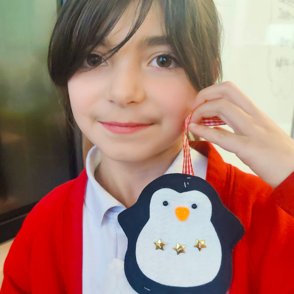 Child holding a felt penguin ornament