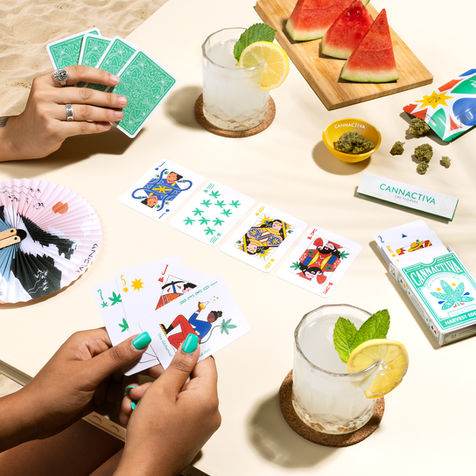 photo of two people at a sunny table playing with a colorful and illustrated deck of cards