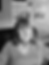 Photo of lady in an office sitting on chair - chest to just over head - newspaper clippings visible in the background