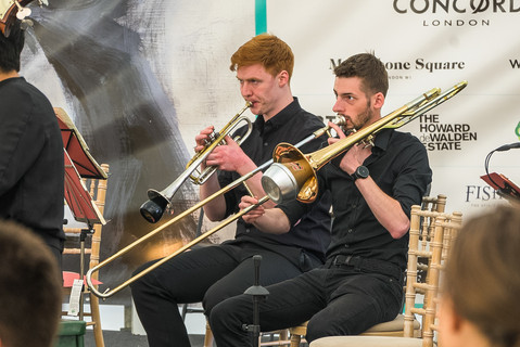 two men are playing trombones 