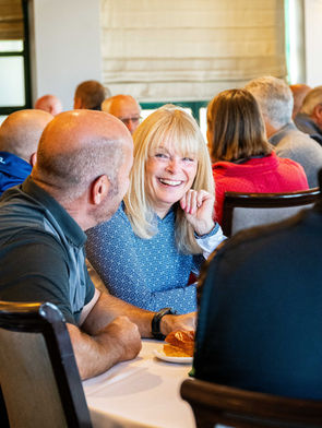 a woman sitting at a table and laughing