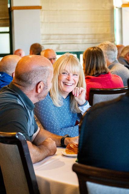 a woman sitting at a table and laughing