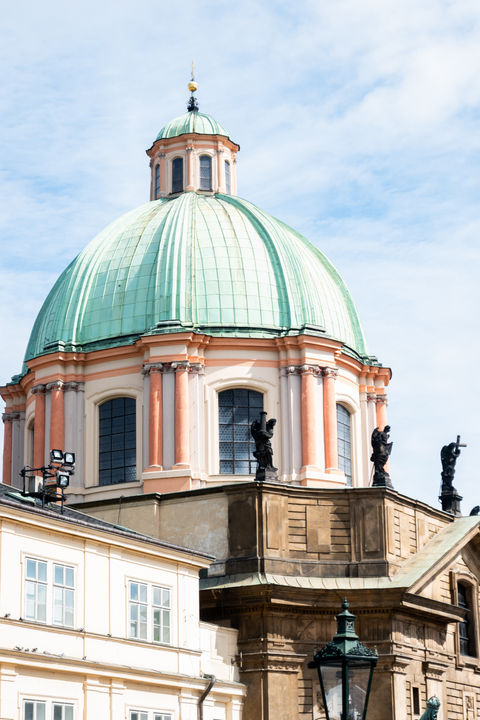 close up of a building with orange pillars and a green dome on top