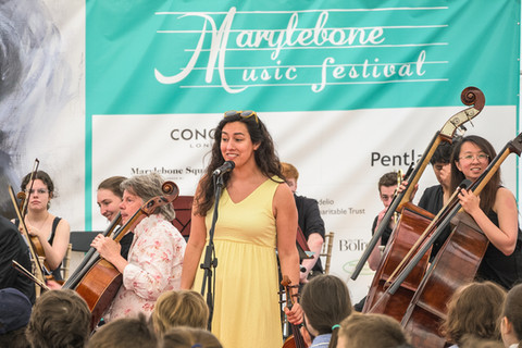 a woman singing into a microphone at the marylebone music festival