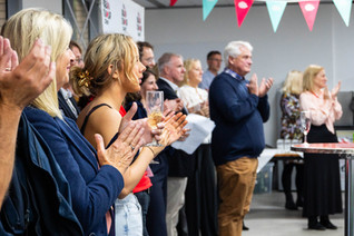 event photography of people applauding and holding glasses