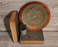 Plate painted with shades of spring green and sky blue with books and props to show scale