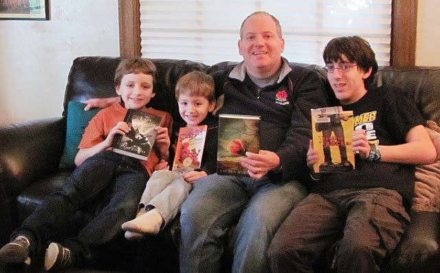 Father and three boys all holding books