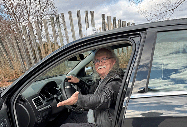 Our taxi driver welcoming you to your ride in our clean vehicle.