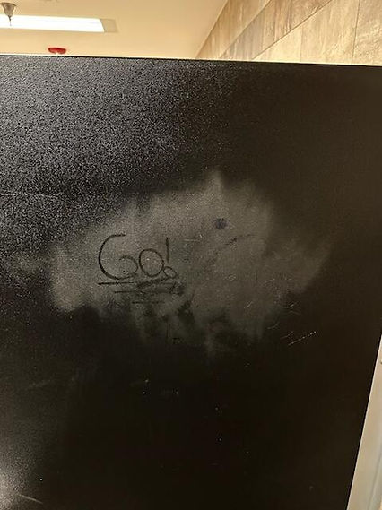 graffiti on bathroom stall wall