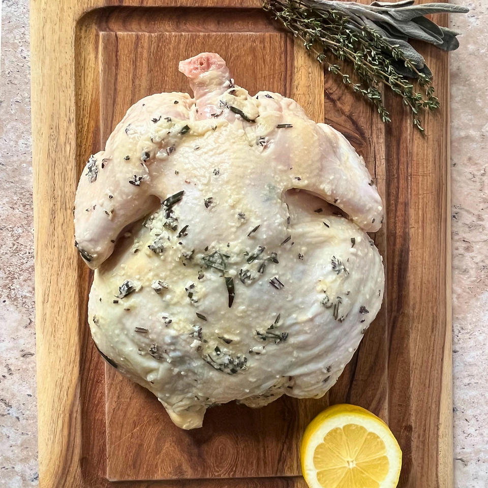 salt koji marinated whole chicken with a cut lemon and herbs