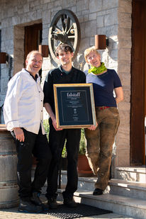 Gerhard, Georg und Barbara Murtinger stehen vor dem Landgasthof Breitenfurt und halten lachend die Falstaff Urkunde in der Hand.