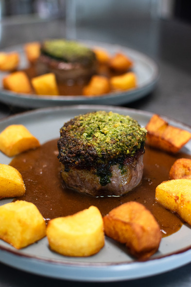 Zart rosa gebratenes Filetsteak unter der Bärlauch-Kruste mit Braterdäpfel und Blattsalat