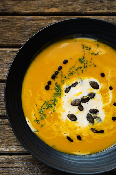 Hausgemachte Kürbicremesuppe mit Kürbiskernen, Schlagobers und Schnittlauch garniert.