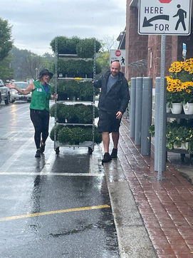 Two Simply Set Merchandisers in a group photo pulling a flower rack to display in the rain