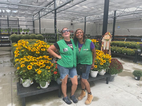 Simply Set Merchandisers in a group photo with their displayed flowers in the background